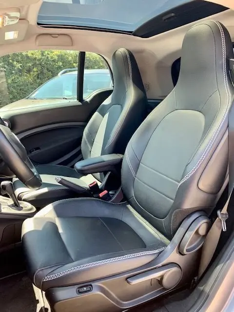 Intérieur du Smart Fortwo électrique 2019, sièges en cuir noir et gris, vue côté conducteur avec toit panoramique ouvert