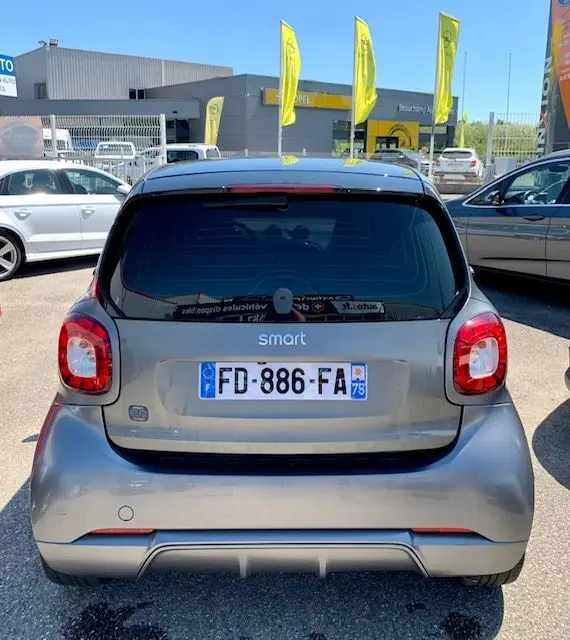 Vue arrière d'une Smart Fortwo Coupé électrique gris 2019, avec vitres teintées et logo Brabus Style visible.