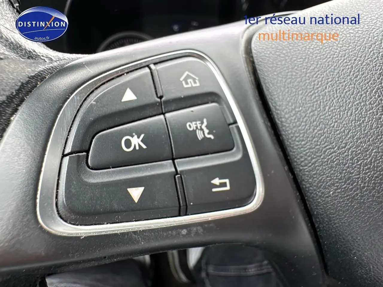 Gros plan sur les commandes au volant de la Mercedes Classe C 180 d business gris alu de 2017, côté gauche.