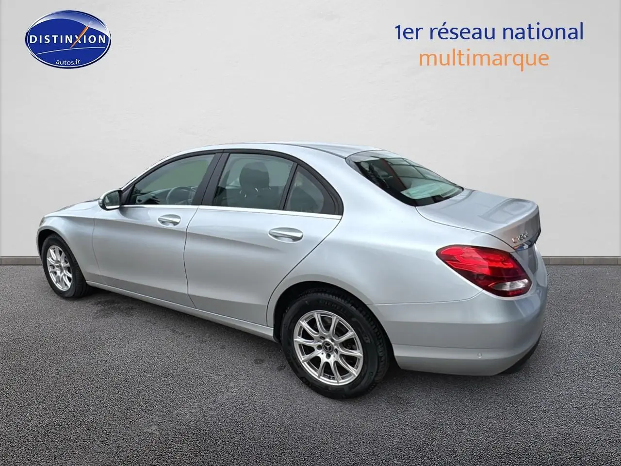 Mercedes Classe C 180 d business gris alu vue 3/4 arrière côté gauche, avec jantes alliage et feux arrière rouges.