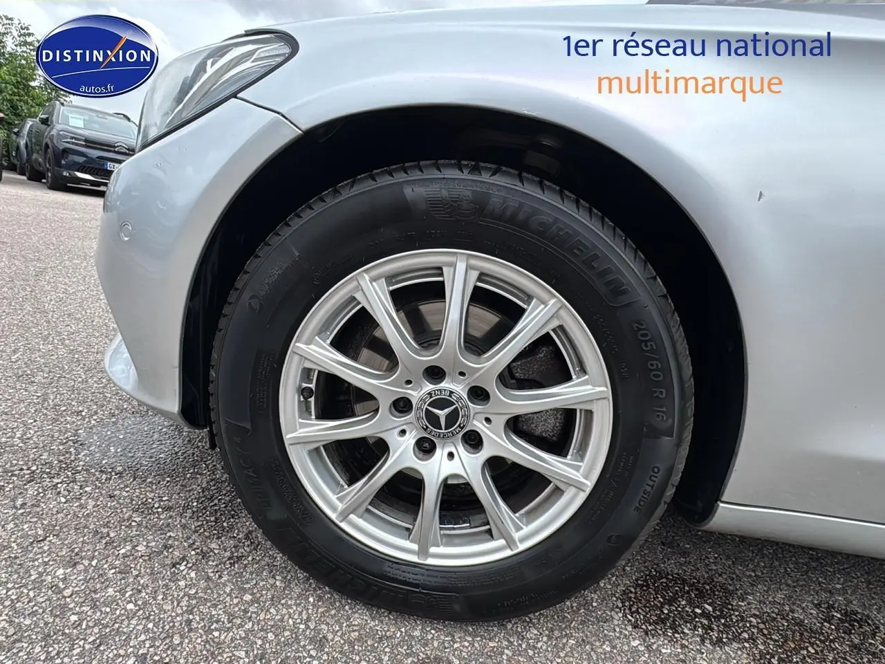 Gros plan sur la roue avant gauche d'une Mercedes Classe C 180 d business gris alu, jante alliage 16 pouces.