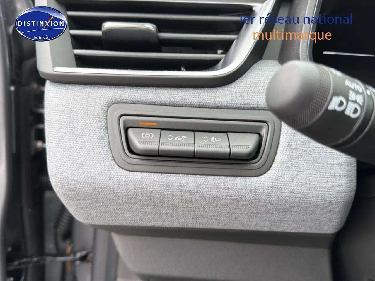 Détail des commandes d’éclairage et verrouillage sur tableau de bord gris clair d’une Renault Clio V 2026.