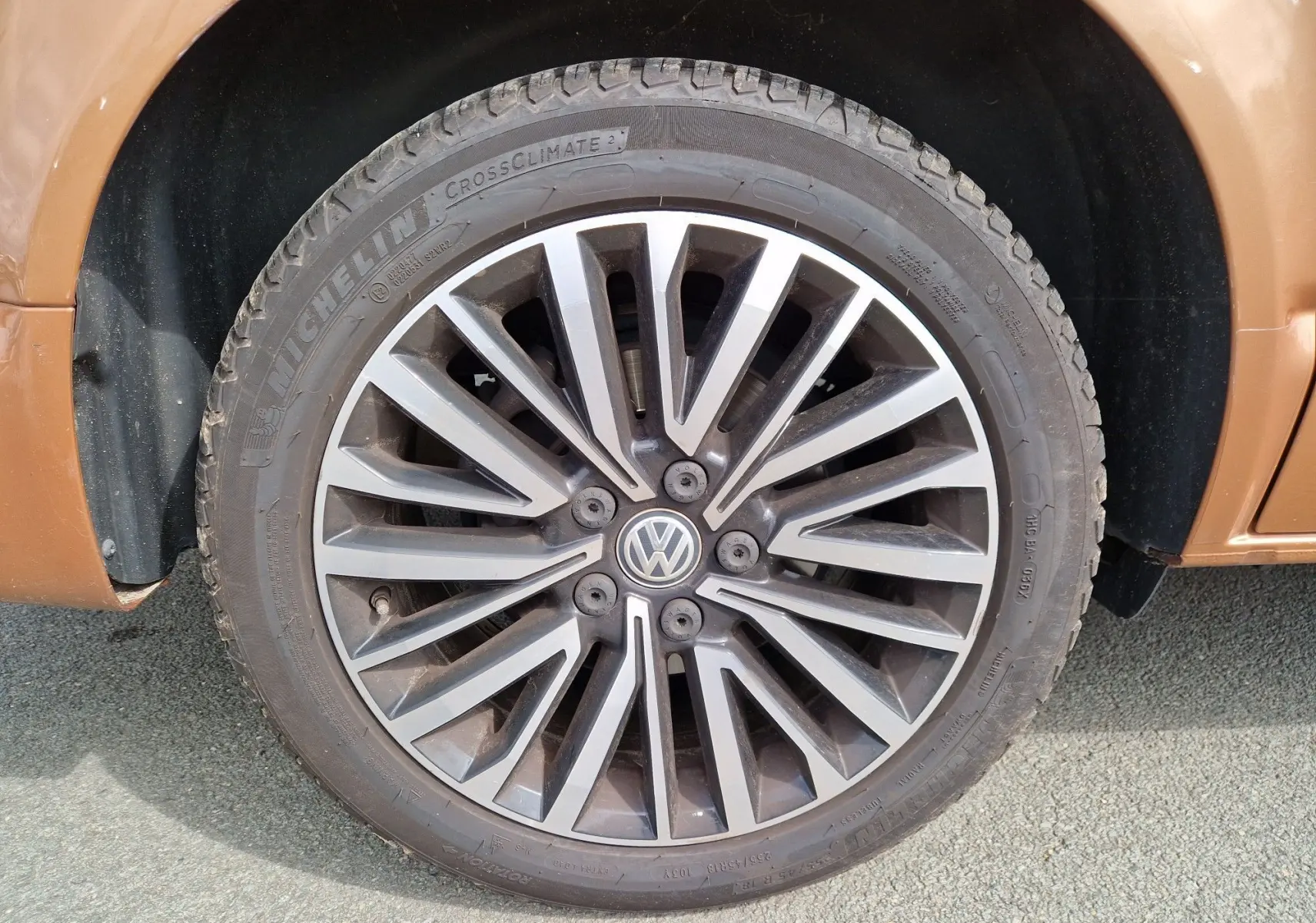 Gros plan sur la roue avant gauche en alliage du Volkswagen California Cooper bronze 2021, soulignant le design moderne.