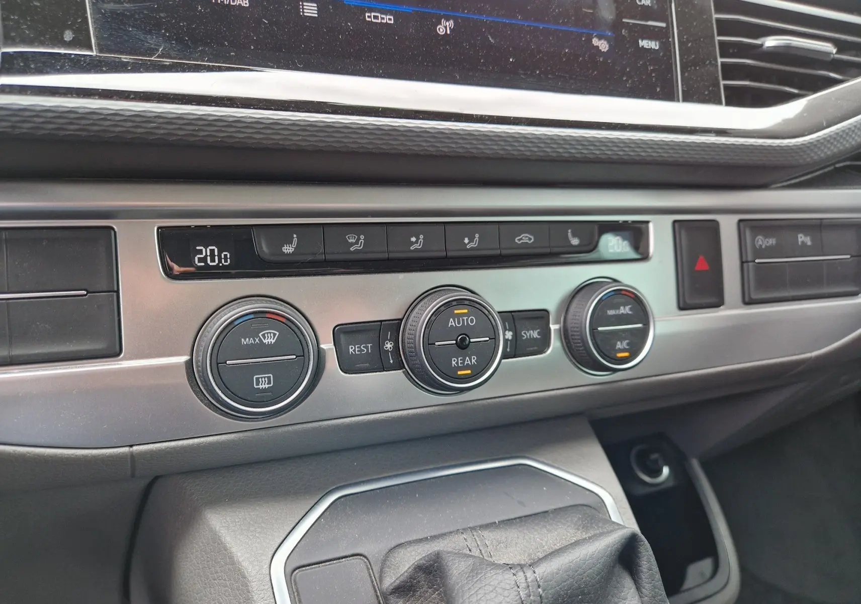 Gros plan sur la console centrale du Volkswagen California 2021, montrant les commandes de climatisation et la boîte automatique.