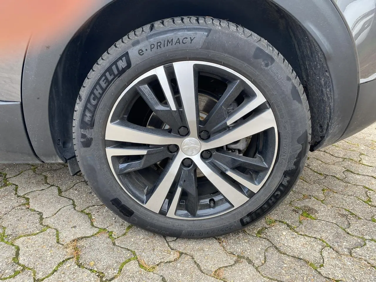 Gros plan sur la roue avant gauche du Peugeot 3008 gris foncé avec jante alliage et pneu Michelin e-Primacy.