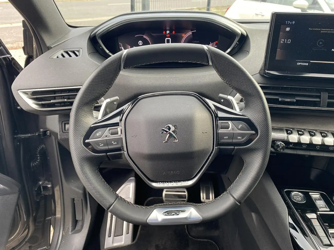 Volant GT en cuir noir du Peugeot 3008 2023 hybride, avec tableau de bord numérique et console centrale moderne.