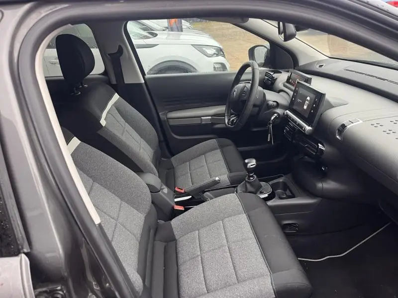 Vue intérieure côté conducteur de la Citroën C4 Cactus 2020 avec sièges tissu gris Mica et tableau de bord moderne.