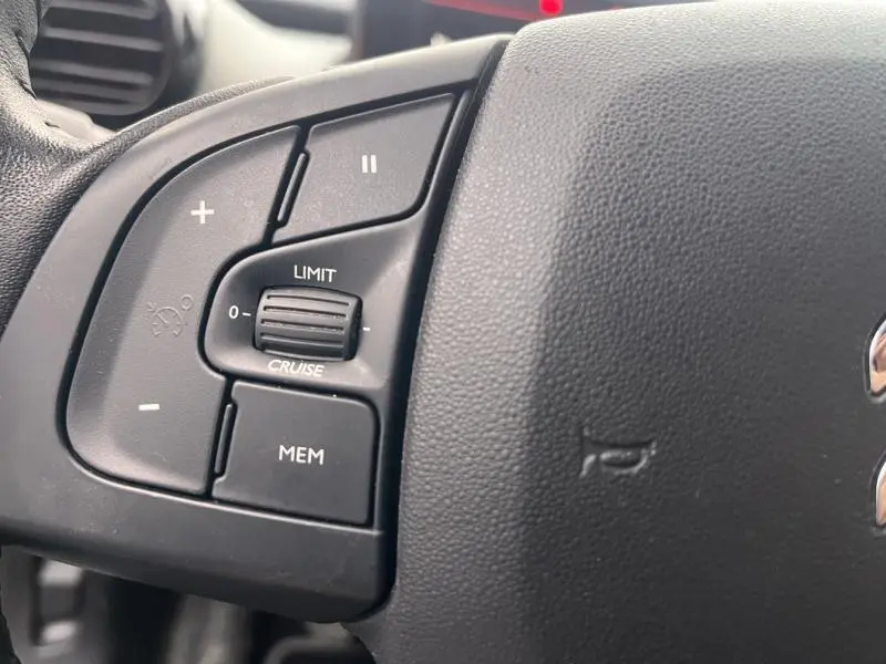 Gros plan sur les commandes de régulateur de vitesse sur le volant noir du Citroën C4 Cactus gris Platinium.