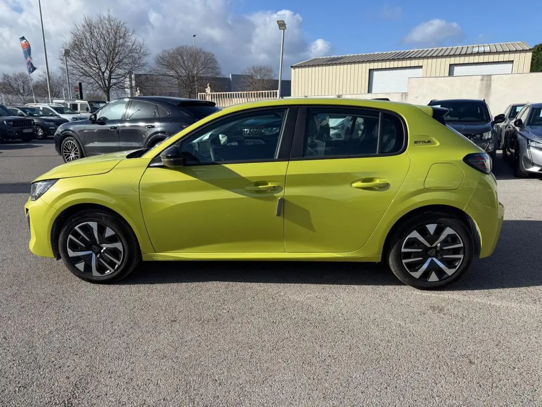 Profil droit d’une Peugeot 208 jaune 2025 Style avec jantes 16 pouces et badge distinctif sur l’aile arrière.