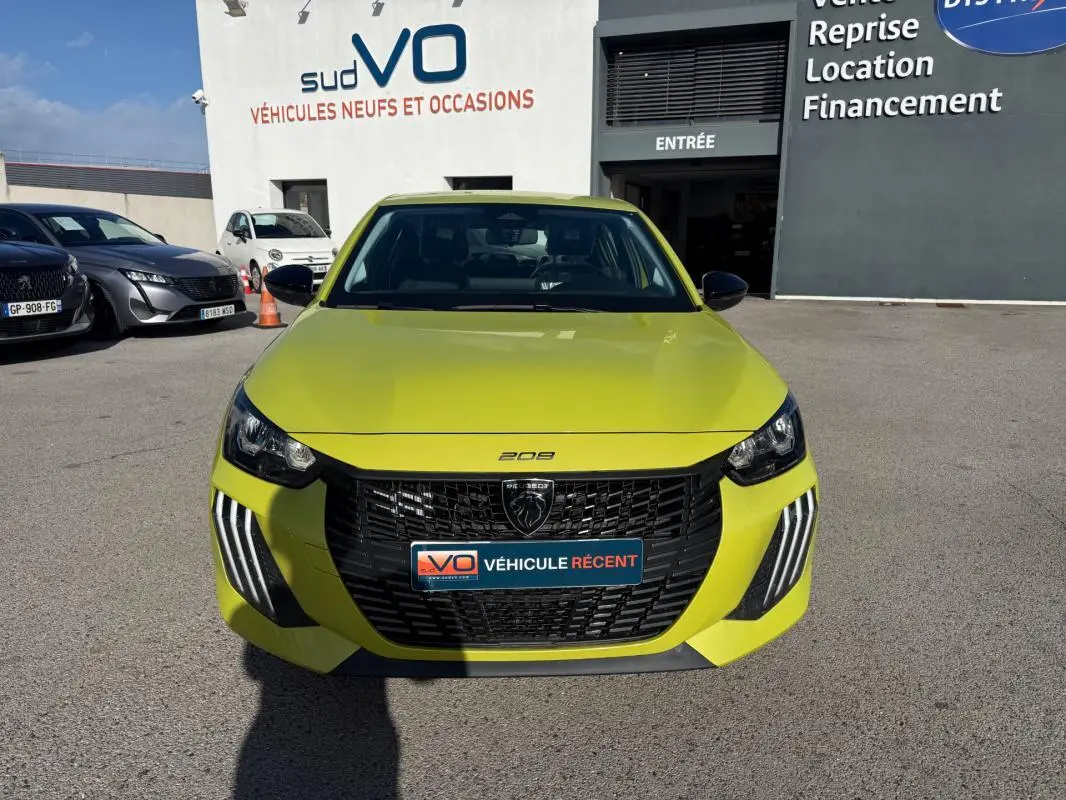 Vue de face d'une Peugeot 208 jaune vif 2025 avec calandre noire et feux diurnes à LED en griffes.