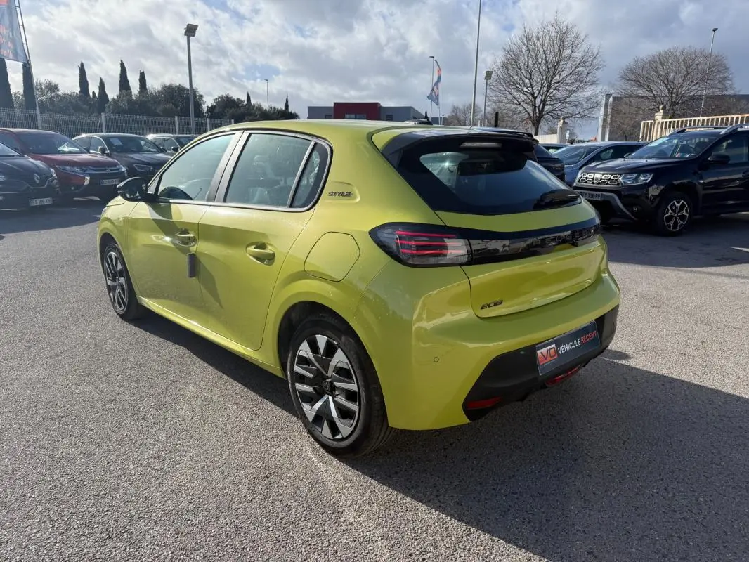 Peugeot 208 jaune vue 3/4 arrière droit, avec jantes 16 pouces et badge Style sur le côté.