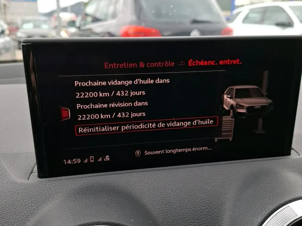 Écran multimédia intérieur affichant l'entretien avec illustration d'un Audi Q2 gris vue de face en 3/4 droit.