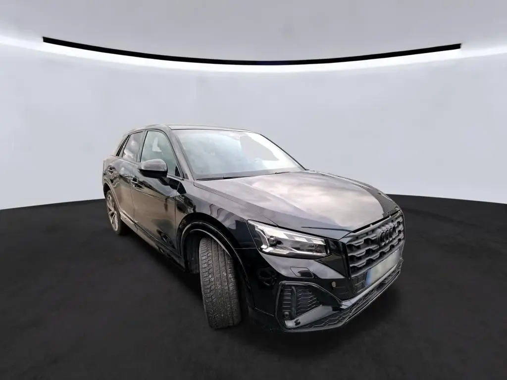 Audi Q2 noir vue 3/4 avant droit, mettant en valeur la calandre distinctive et les jantes alliage.