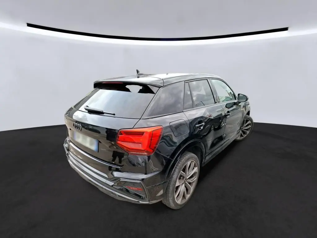 Audi Q2 noire vue 3/4 arrière droit, avec jantes alliage et feux arrière LED distinctifs.