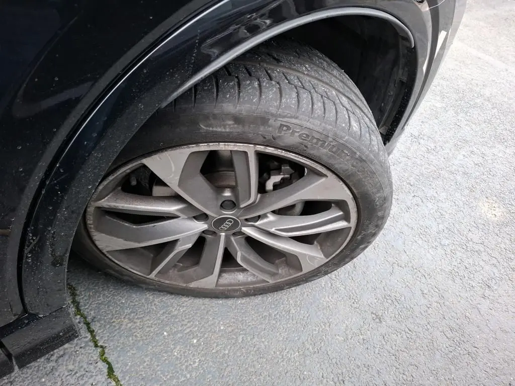 Gros plan sur la roue avant droite noire d’un Audi Q2 1.5 TFSI 2023 avec jante alu à 5 doubles branches.