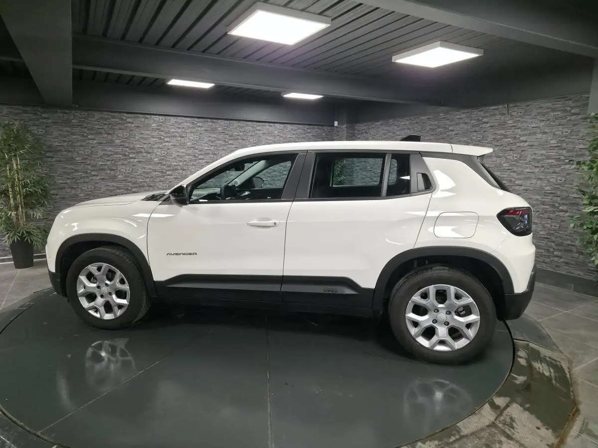 Vue de profil côté gauche du Jeep Avenger blanc 2025 avec jantes alliage et détails noirs contrastants.