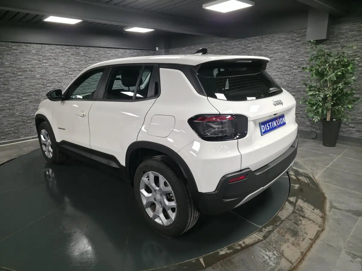 Jeep Avenger blanc en vue 3/4 arrière droit, avec jantes alliage 17 pouces et feux arrière foncés.