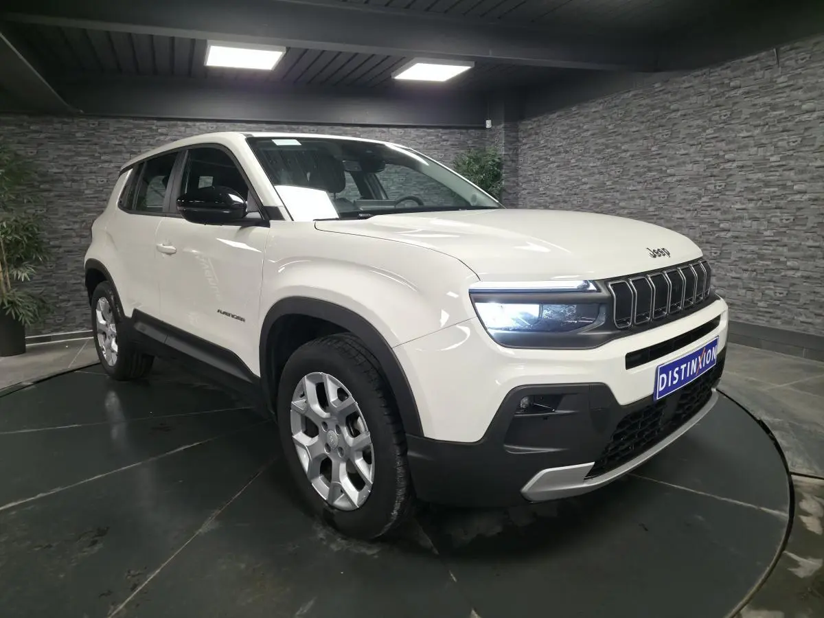 Jeep Avenger blanc en 3/4 avant droit, avec calandre noire distinctive et jantes alliage 17 pouces.