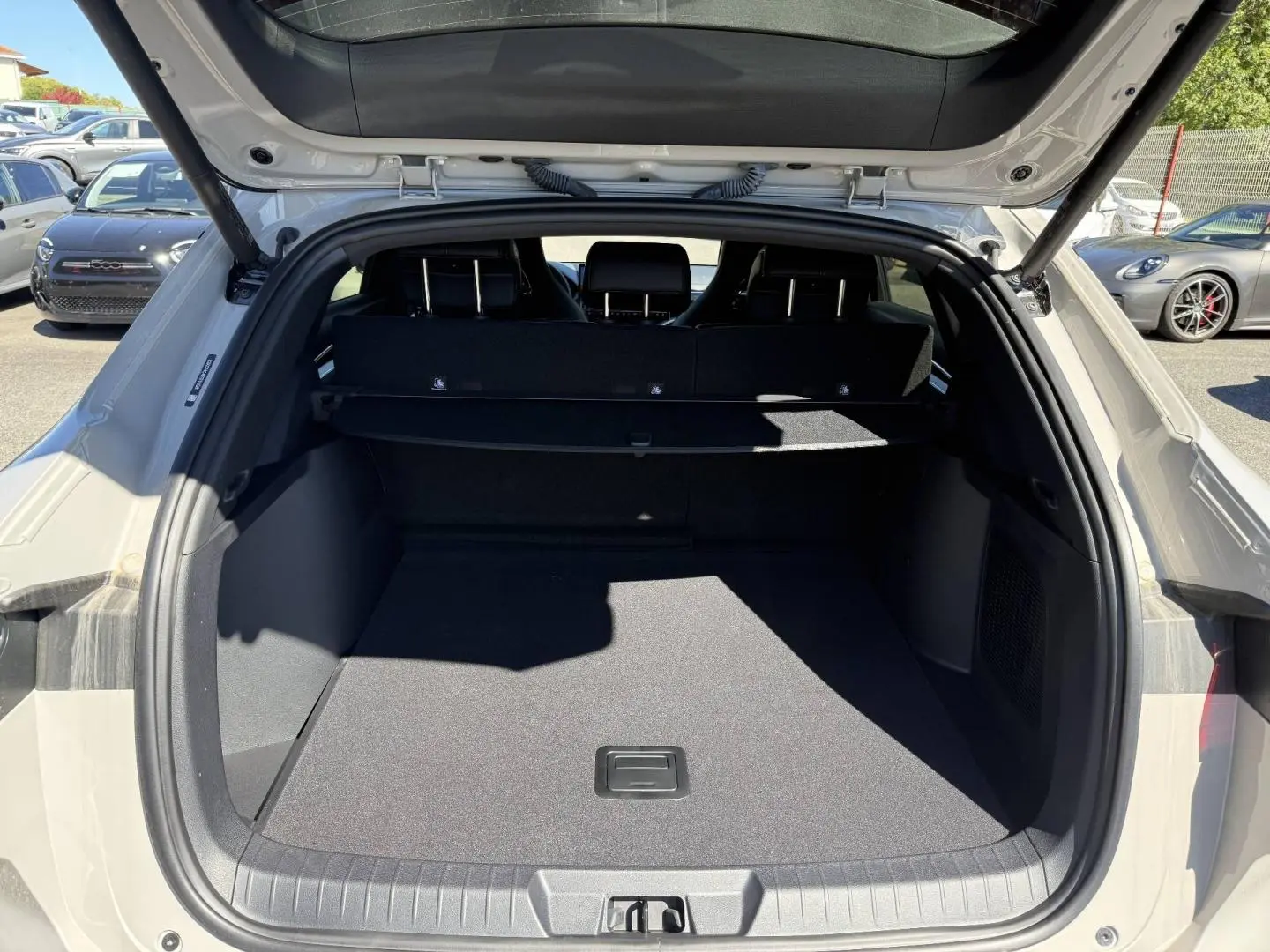Coffre ouvert vu de l'arrière d'un BYD SEAL U 1.5 DM-i 218ch Boost Boundless Cloud métallisé, avec banquette arrière noire.