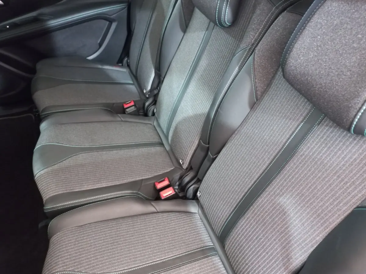 Vue rapprochée des sièges arrière gris foncé du Peugeot 5008, montrant les finitions tissu et cuir avec surpiqûres contrastantes.