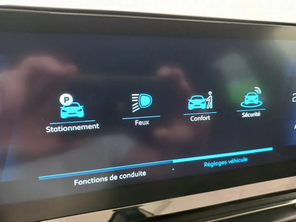 Écran tactile du tableau de bord du Peugeot 5008 2021 affichant les options stationnement, feux, confort et sécurité.