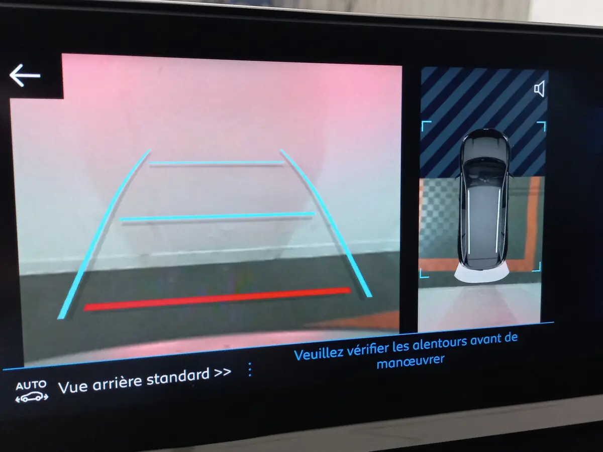 Affichage caméra de recul et vue 3D du Peugeot 5008 gris foncé en stationnement, avec guidage dynamique.