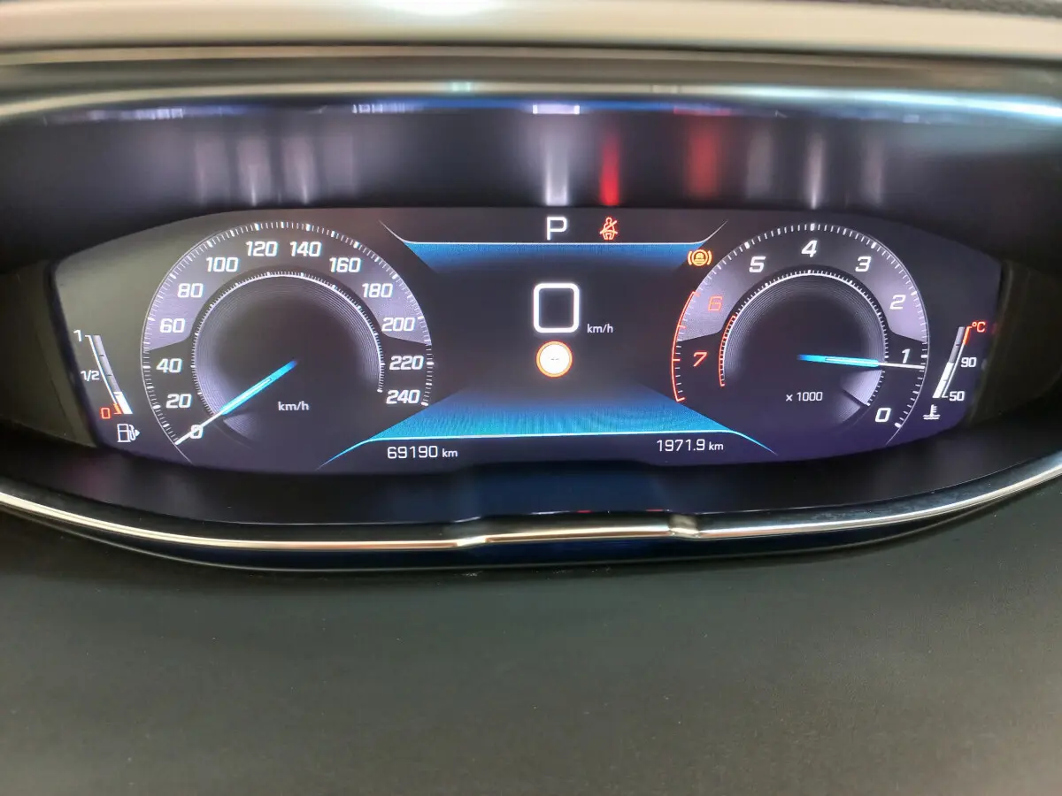 Affichage numérique du tableau de bord du Peugeot 5008 2021, vitesse à 0 km/h, compte-tours et jauge essence visibles.
