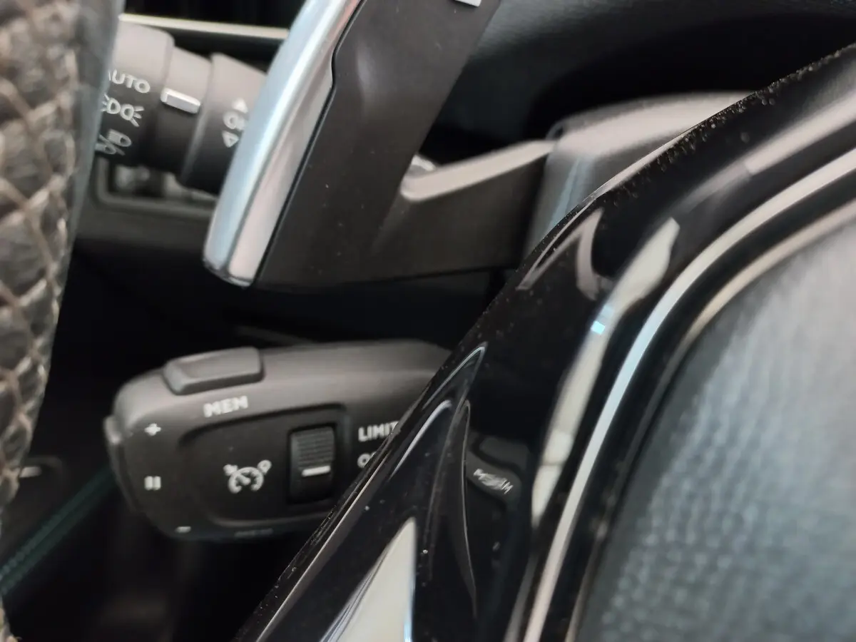 Gros plan sur la commande de régulateur de vitesse à gauche du volant cuir du Peugeot 5008 gris foncé 2021