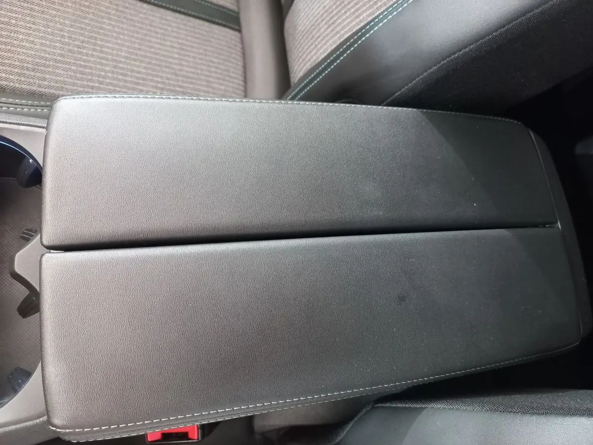 Accoudoir central en cuir noir avec surpiqûres contrastantes dans l'habitacle du Peugeot 5008 Gris foncé.