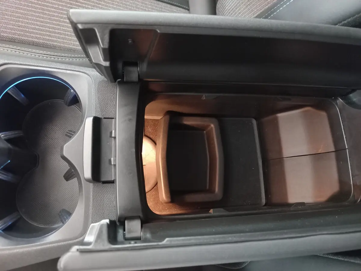 Vue rapprochée de la console centrale ouverte avec porte-gobelets éclairés sur Peugeot 5008 gris foncé 2021.
