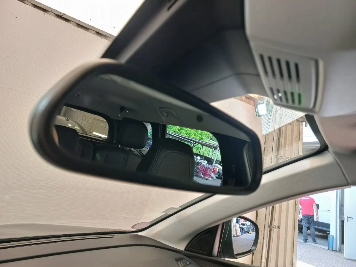 Rétroviseur intérieur montrant les sièges arrière noirs du Peugeot 5008 gris foncé, vue côté conducteur.