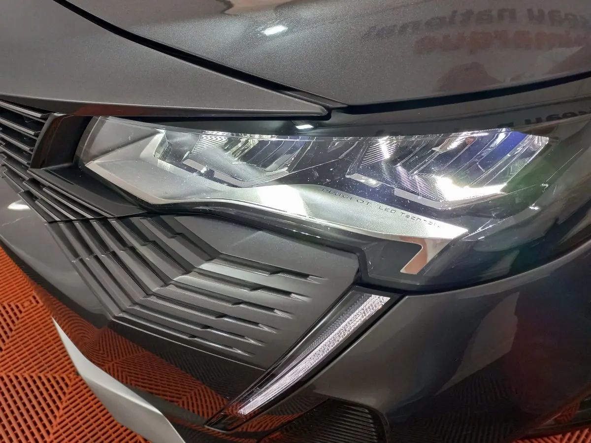 Gros plan sur le phare avant droit LED et la calandre du Peugeot 5008 gris foncé, version 2021 Allure Pack.