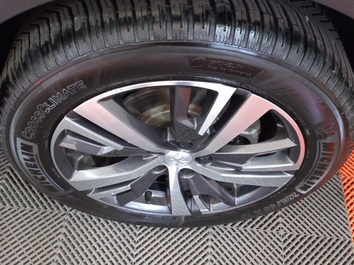 Gros plan sur la jante alliage et pneu Michelin d'un Peugeot 5008 gris foncé, vue latérale rapprochée.
