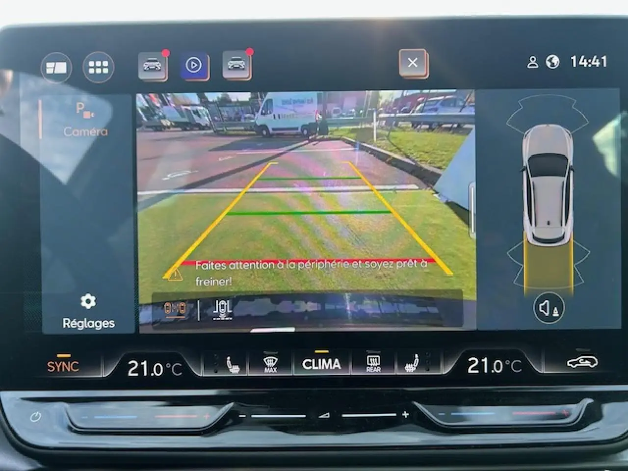 Écran tactile du système d'info-divertissement montrant la caméra de recul du CUPRA Formentor blanc neige en stationnement.