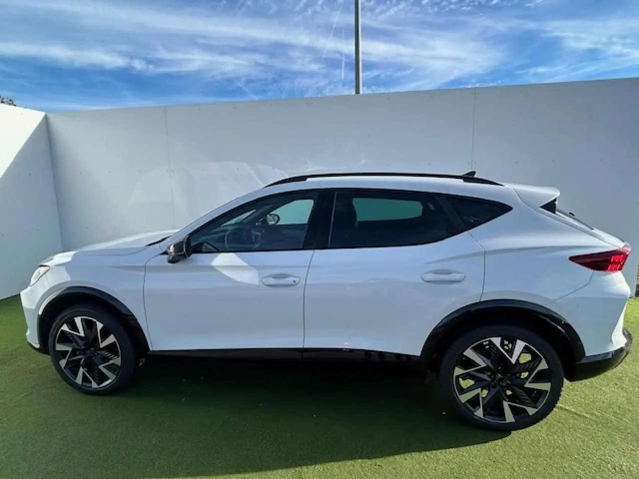 Vue de profil côté gauche du CUPRA Formentor blanc neige avec jantes alliage 19 pouces au design distinctif.