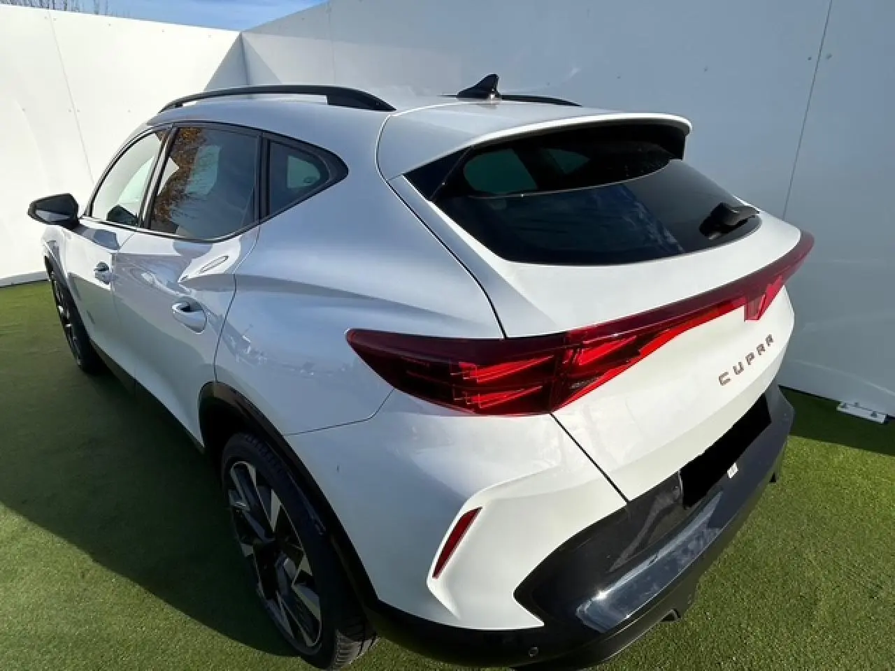 Vue 3/4 arrière droite du CUPRA Formentor blanc neige avec feux arrière Tri-LED et jantes alliage 19 pouces Sandstorm.