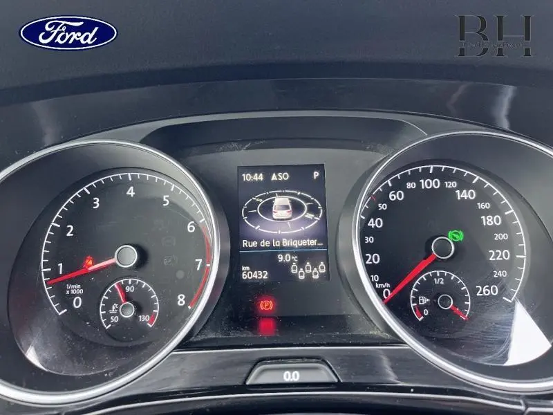 Tableau de bord du Volkswagen Touran 1.5 TSI en vue frontale, affichage numérique et compte-tours visibles.