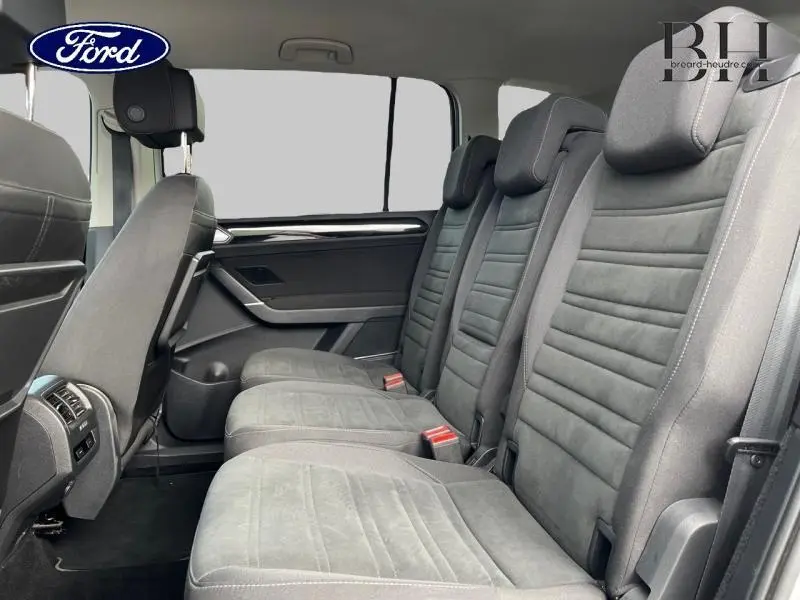 Vue latérale intérieure sur la deuxième rangée de sièges en cuir noir du Volkswagen Touran 2021, finition Carat.