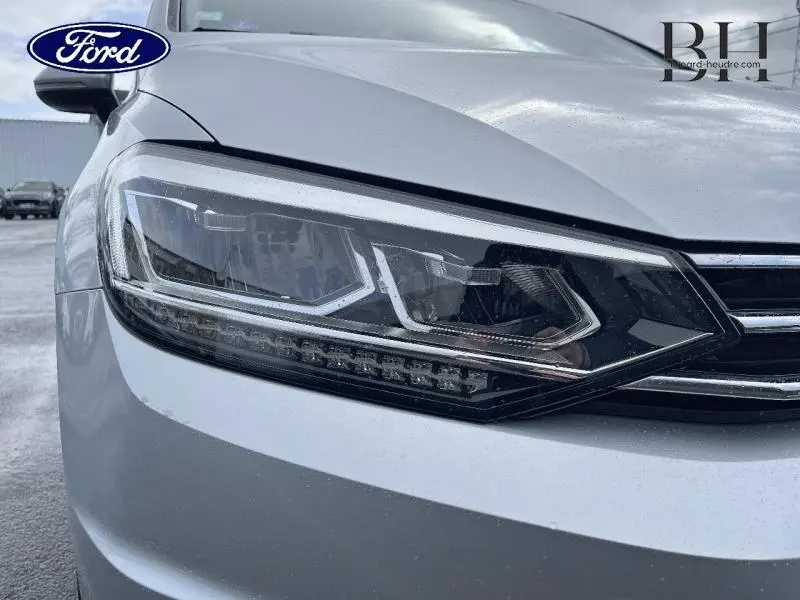 Gros plan sur le phare avant gauche d'un Volkswagen Touran 2021 couleur Reflet d'Argent Métallisée.