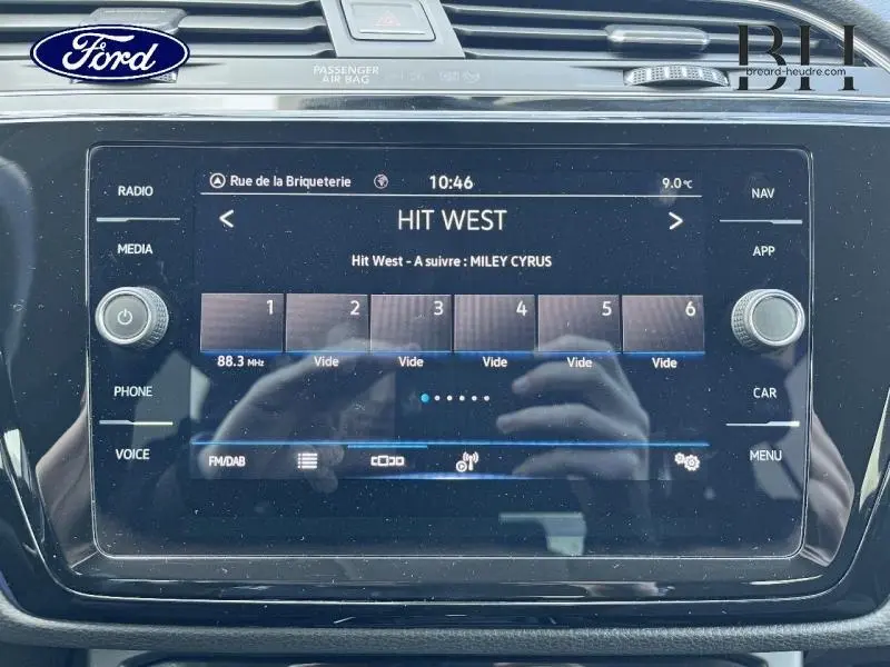 Écran tactile central du Volkswagen Touran 2021 en Reflet d'Argent, affichant la radio Hit West.