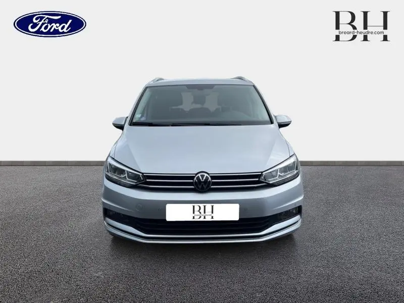 Vue avant d'un Volkswagen Touran 1.5 TSI Reflet d'Argent Métallisée avec calandre chromée et phares LED.