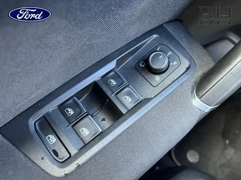 Gros plan sur les commandes de lève-vitres et réglage des rétroviseurs d'une Volkswagen Touran 2021, intérieur noir.