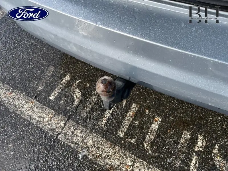 Gros plan sur l'attelage électrique rouillé à l'arrière d'un Volkswagen Touran Reflet d'Argent métallisé.