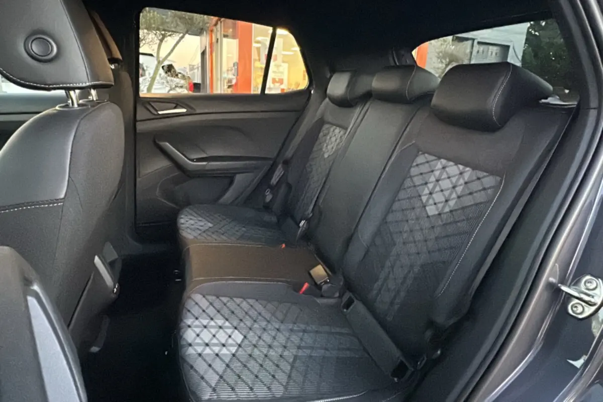 Vue intérieure côté droit sur la banquette arrière en tissu noir avec motifs géométriques du Volkswagen T-Cross gris cendré.