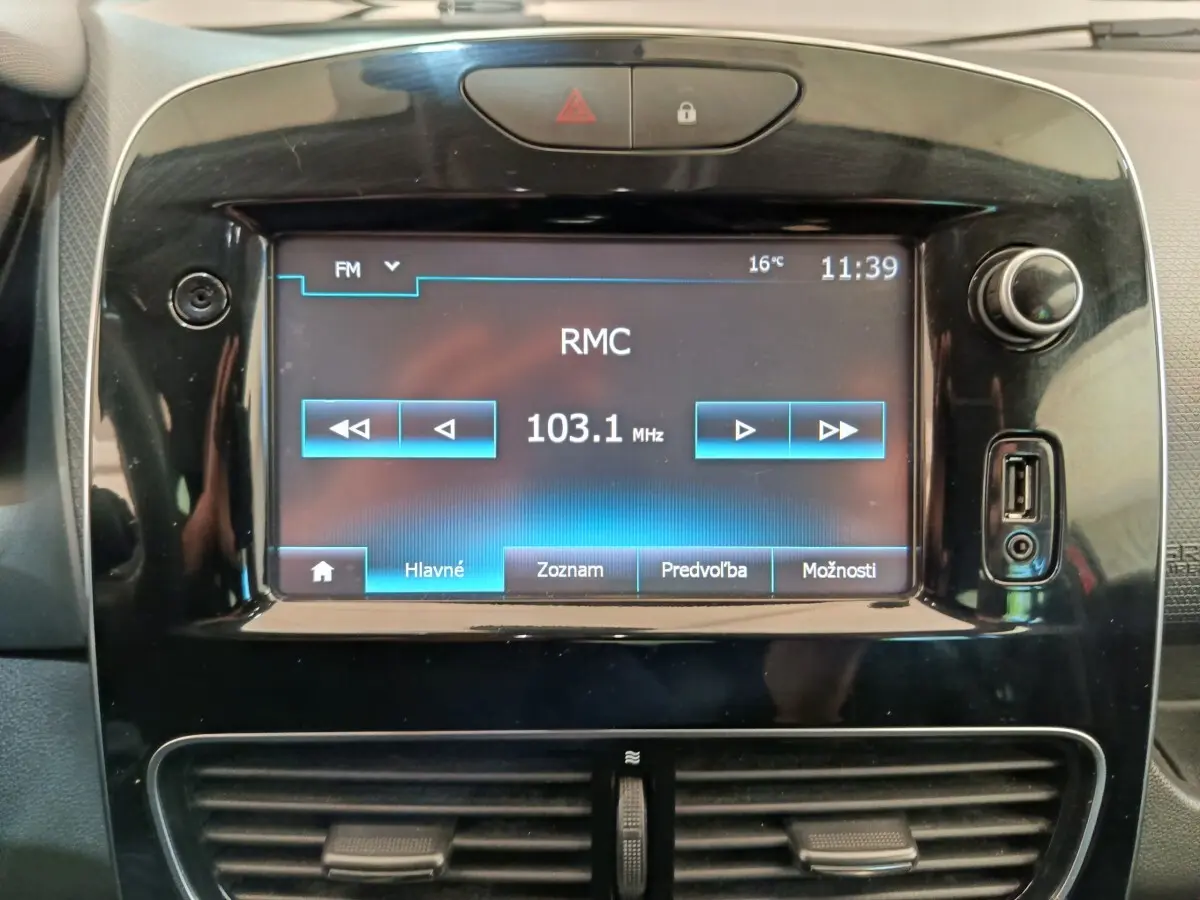 Écran tactile central de la Renault Clio Intens 2018 affichant une radio FM, entouré de commandes noires brillantes.