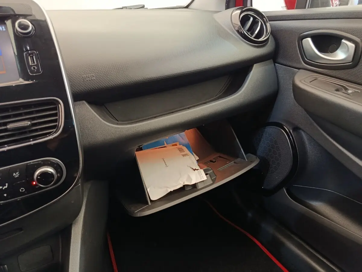 Intérieur côté passager de la Renault Clio Intens 2018, boîte à gants ouverte avec documents visibles.