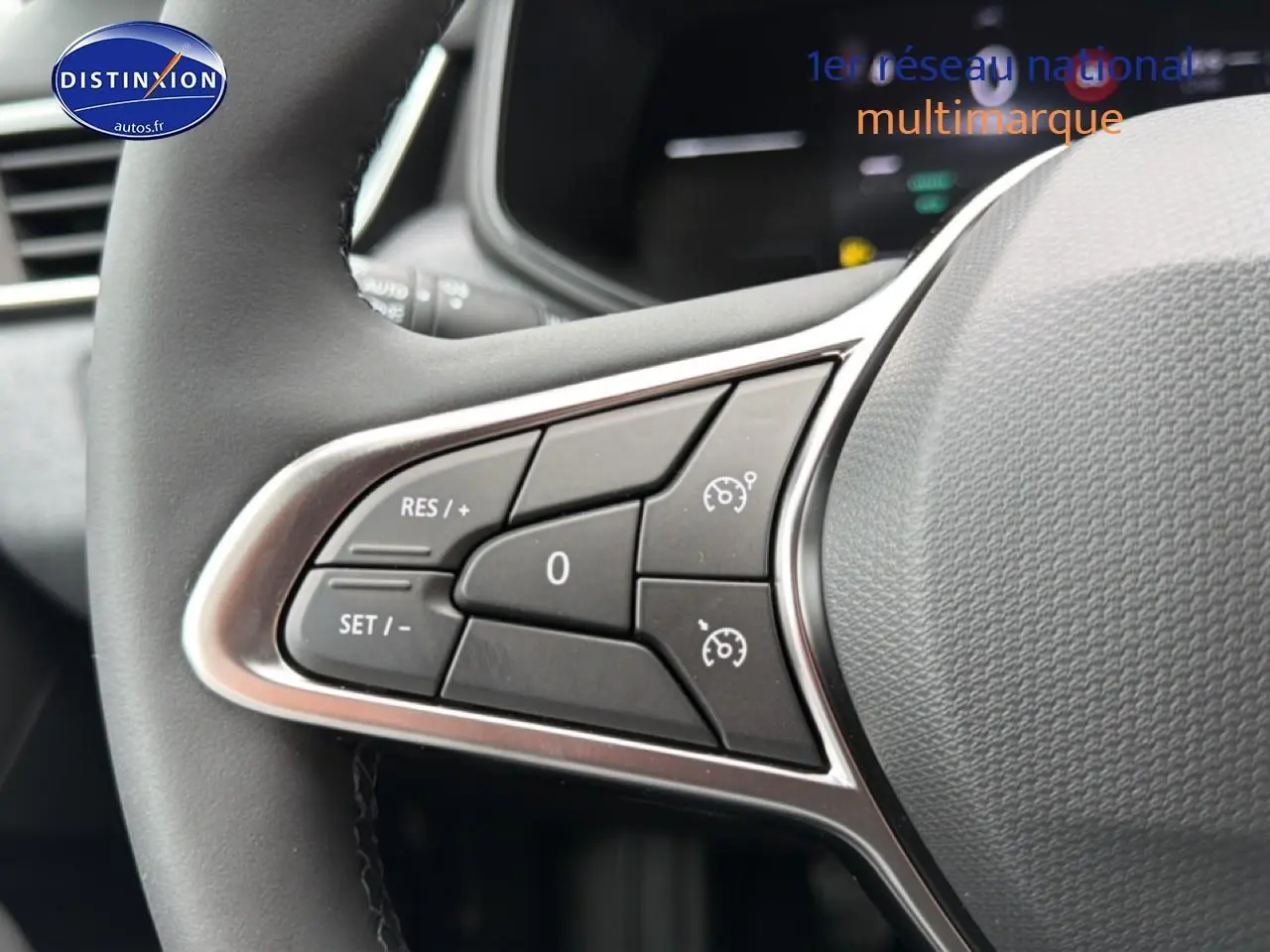 Gros plan sur les commandes de régulateur de vitesse au volant d'une Renault Clio V noire, intérieur moderne.