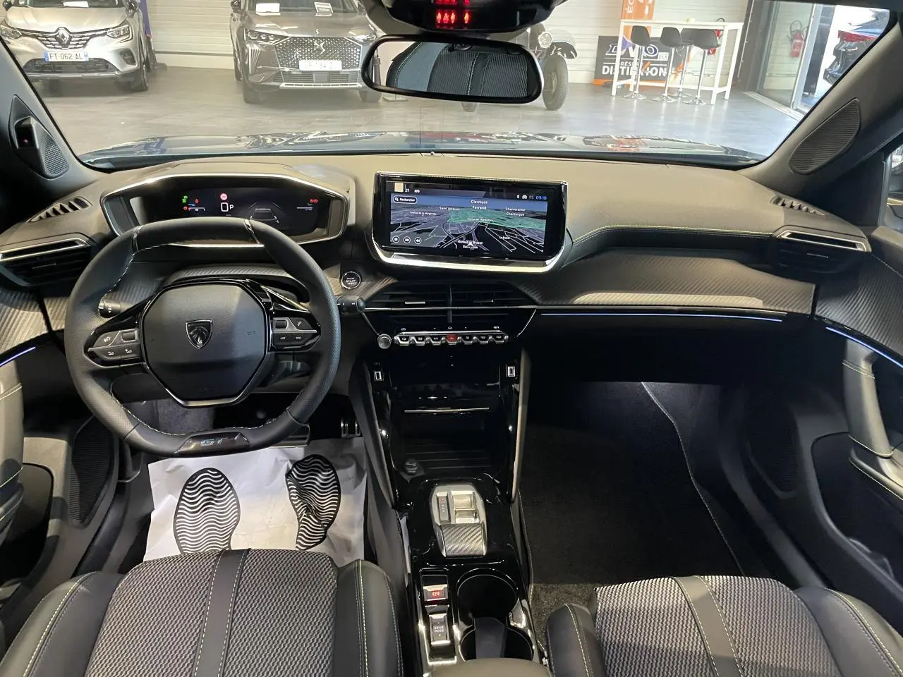 Vue intérieure avant du Peugeot 2008 hybride 2026 avec tableau de bord numérique et écran tactile central.