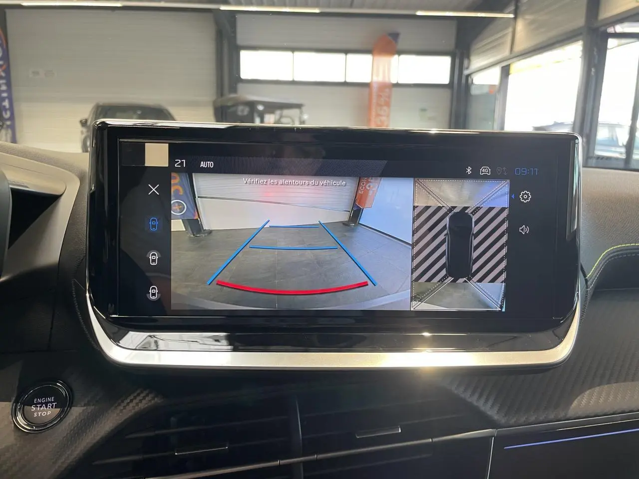 Vue rapprochée de l'écran tactile intérieur affichant la caméra de recul et la vue 360° du Peugeot 2008 hybride bleu.