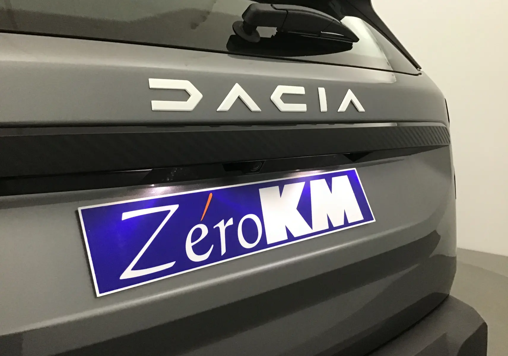 Gros plan sur l'arrière gris schiste du Dacia Bigster 2025 avec logo et plaque Zéro KM visible.